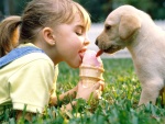 Niña y cachorro compartiendo un helado