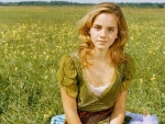 Emma Watson sentada en un prado