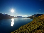 Reflejo de un sol resplandeciente sobre las aguas de un lago