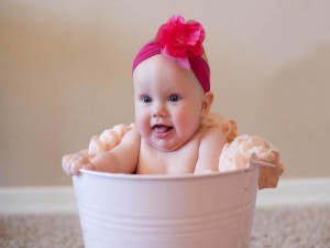 Bebé bañándose en un cubo