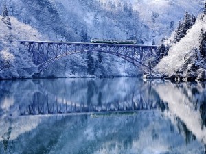 Postal: Tren atravesando un puente bajo un paisaje invernal