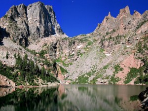 Postal: Inmensas rocas que se reflejan en un gran lago con aguas transparentes