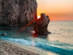 El Sol entre dos rocas, en una playa en la isla de Milo (Grecia)