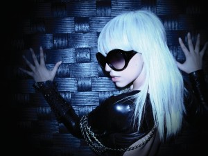 Postal: Lady Gaga de espaldas, vestida de cuero y con gafas de sol