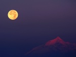La luna iluminando la cima de la montaña