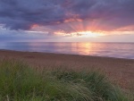 El sol bajo las nubes en una playa de Hunstanton, en la costa de Norfolk, Inglaterra