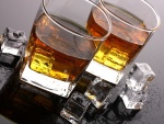 Dos vasos con whisky y cubitos de hielo