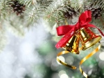 Campanitas doradas colgadas de un pino de Navidad