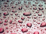 Gotas de agua sobre una superficie roja