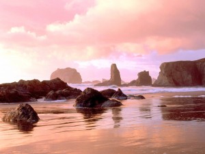Postal: Rocas en la playa, bajo un cielo rosado