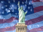 La Estatua de la Libertad con la bandera americana de fondo