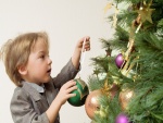 Un niño decorando el árbol de Navidad