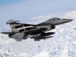 Un F-16 Fighting Falcon sobrevolando una zona helada