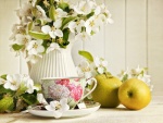 Taza de té, acompañada de flores de jazmín y manzanas verdes