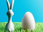 Conejo de Pascua junto a un huevo