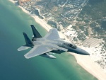 Avión de combate sobrevolando una playa