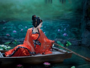 Mujer oriental navegando entre flores de loto