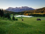 Cabañas en unas praderas al pie de los Alpes