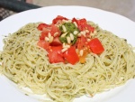 Espagueti con salsa pesto, piñones y dados de tomate natural