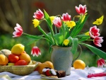 Mesa con tulipanes, frutas y un trozo de pastel