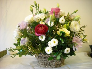 Cesta con flores variadas en tonos blancos y rosas