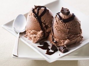 Dos bolas de helado de chocolate decoradas con más chocolate
