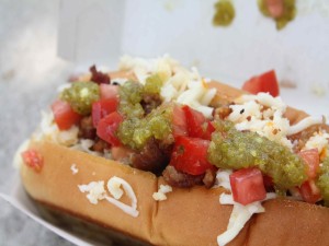 Hot dog con dados de tomate, queso y más