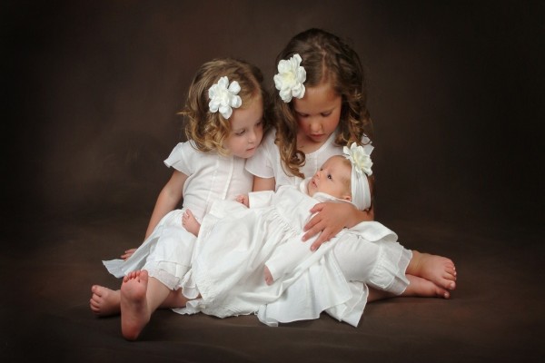 Dos nenas sosteniendo un bebé
