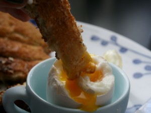 Mojando pan en la yema de un huevo