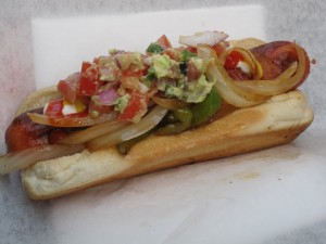 Hot dog con cebolla, guacamole y bacon