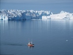 Barco navegando cerca de un fiordo de hielo en Groenlandia