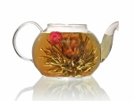 Tetera con hojas de té y flores