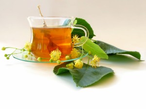 Taza de té con flores y hojas verdes