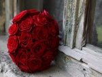 Bola de rosas rojas junto a una ventana de madera