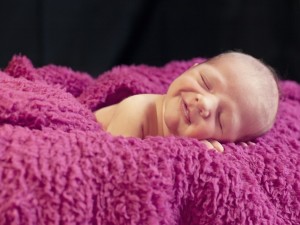 Postal: Bebé descansando sonriente