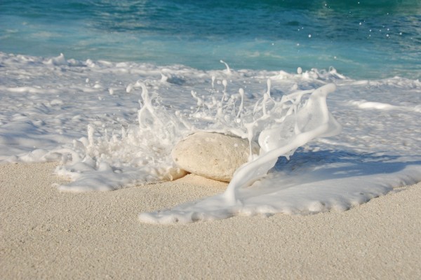 Espuma de mar chocando contra una piedra blanca