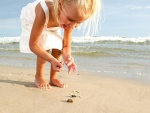 Niña recogiendo conchas en la playa