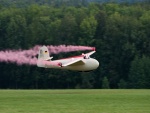 Avioneta despidiendo humo rosa