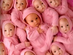 Bebé rodeado de muñecos