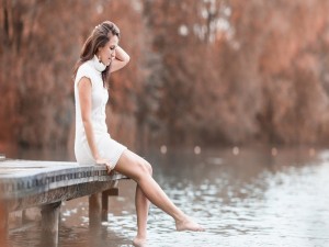 Mujer sentada junto al lago