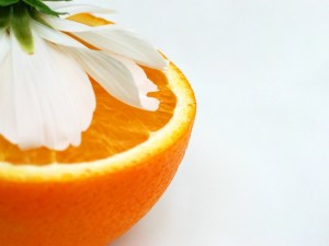 Postal: Media naranja y una flor de azahar