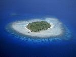 Isla con palmeras rodeada de arrecifes de coral