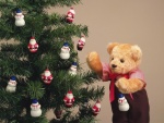 Peluche frente a un árbol de Navidad