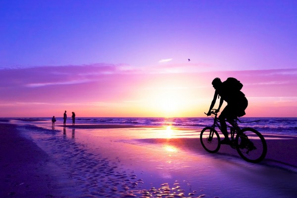 Recorriendo la playa al atardecer en bicicleta