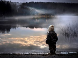 Niño mirando un lago en la noche