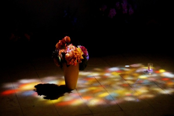 Un jarrón con flores en el piso