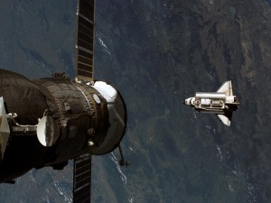Postal: Satélite y transbordador espacial en órbita
