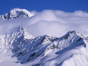 Postal: Nubes sobre las montañas nevadas