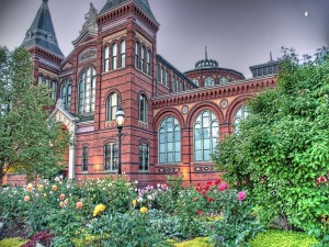 Postal: Jardín de flores rodeando un bonito edificio