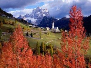 Postal: Pueblo en las montañas visto desde los árboles rojos